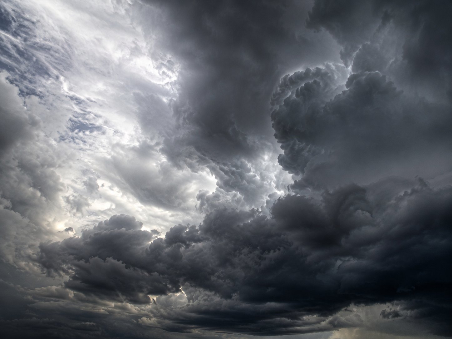 Heavy dark storm clouds with a small opening of light